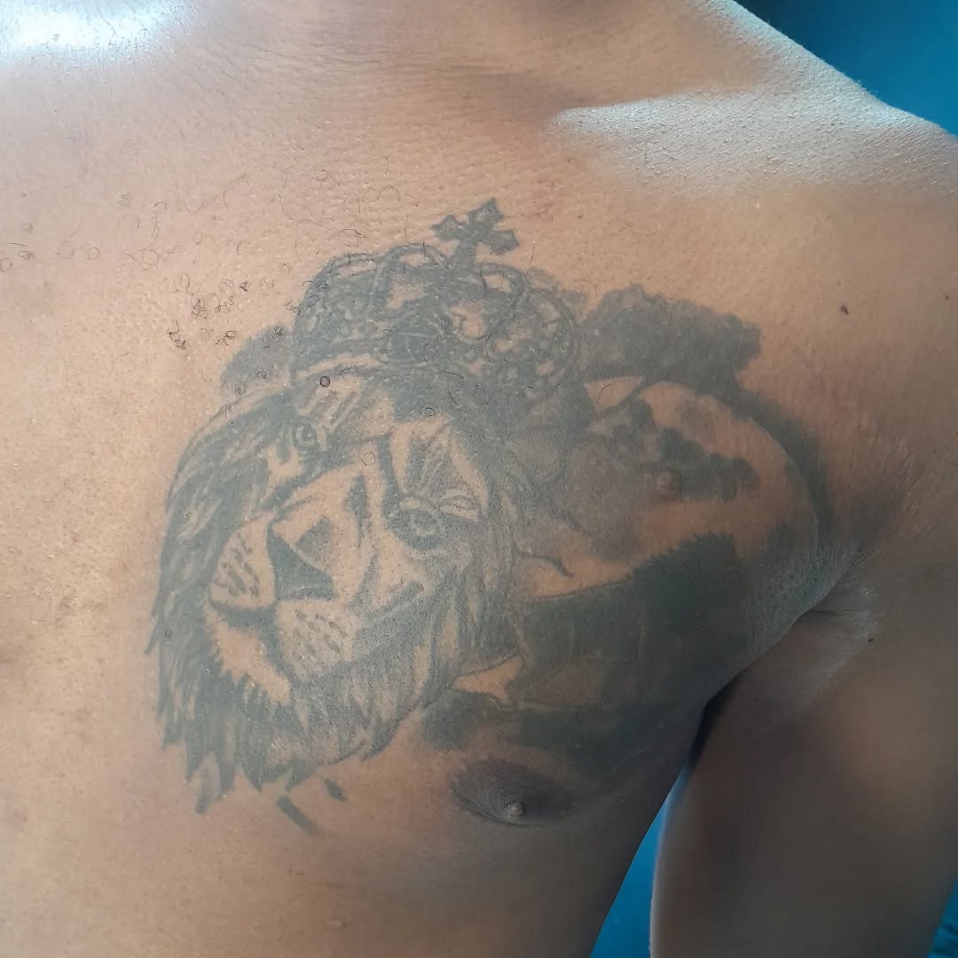 Before: client's unwanted lion chest tattoo before the rose cover-up